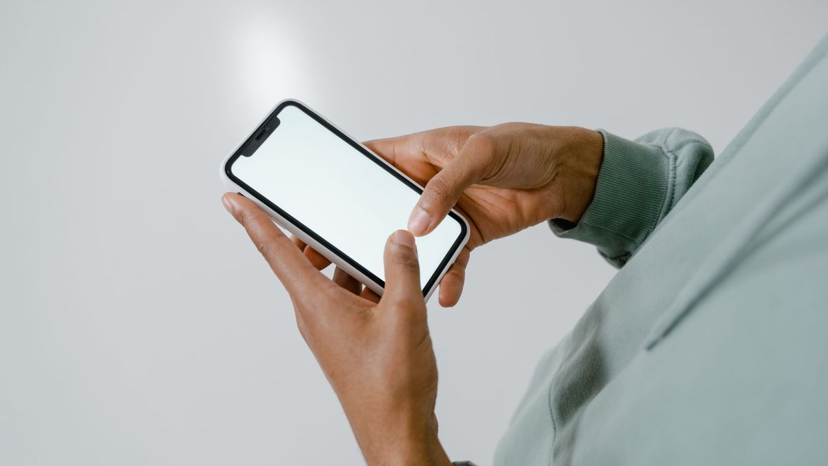 Hands holding an iPhone, downloading a video in Safari