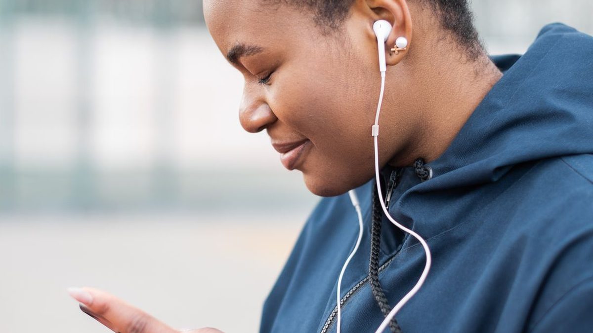 Man listening to music with an earbud and his phone