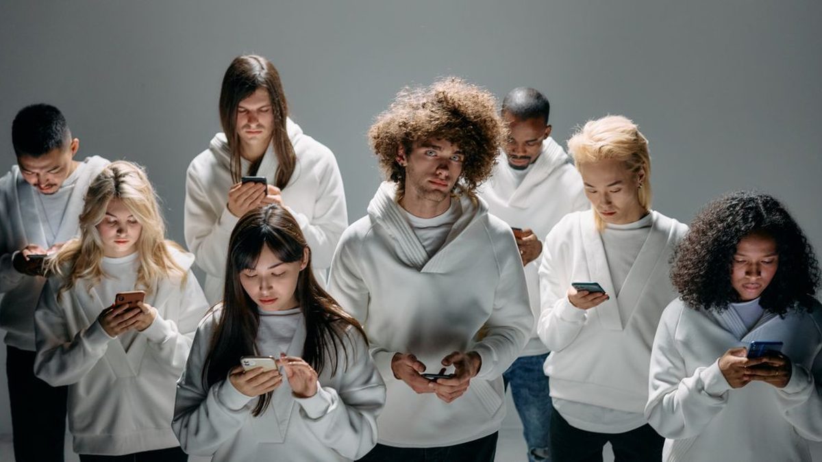 Group of friends laughing while watching a video on a phone