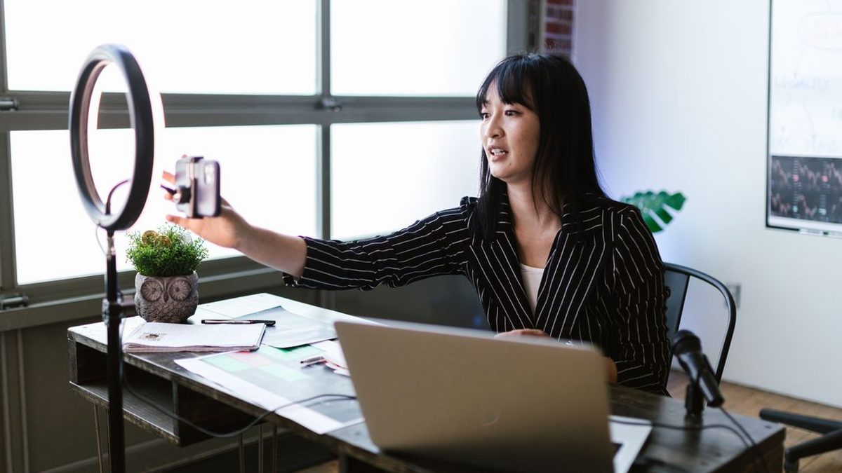 Creator recording a video at her desk with a ring light
