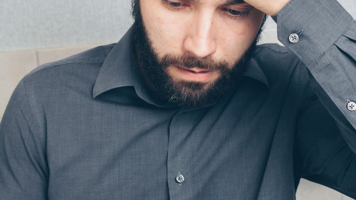 Frustrated man staring at his phone when a download fails