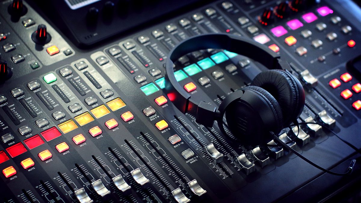Headphones resting on a DJ audio mixer