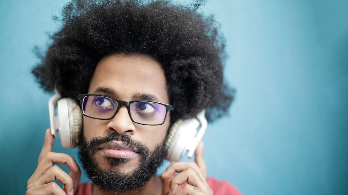 Puzzled man holding headphones, hearing no sound